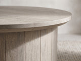 Close-up of the Tolentino Whitewashed Mango Drum Coffee Table: the overhanging top over the vertical mango planks of the drum