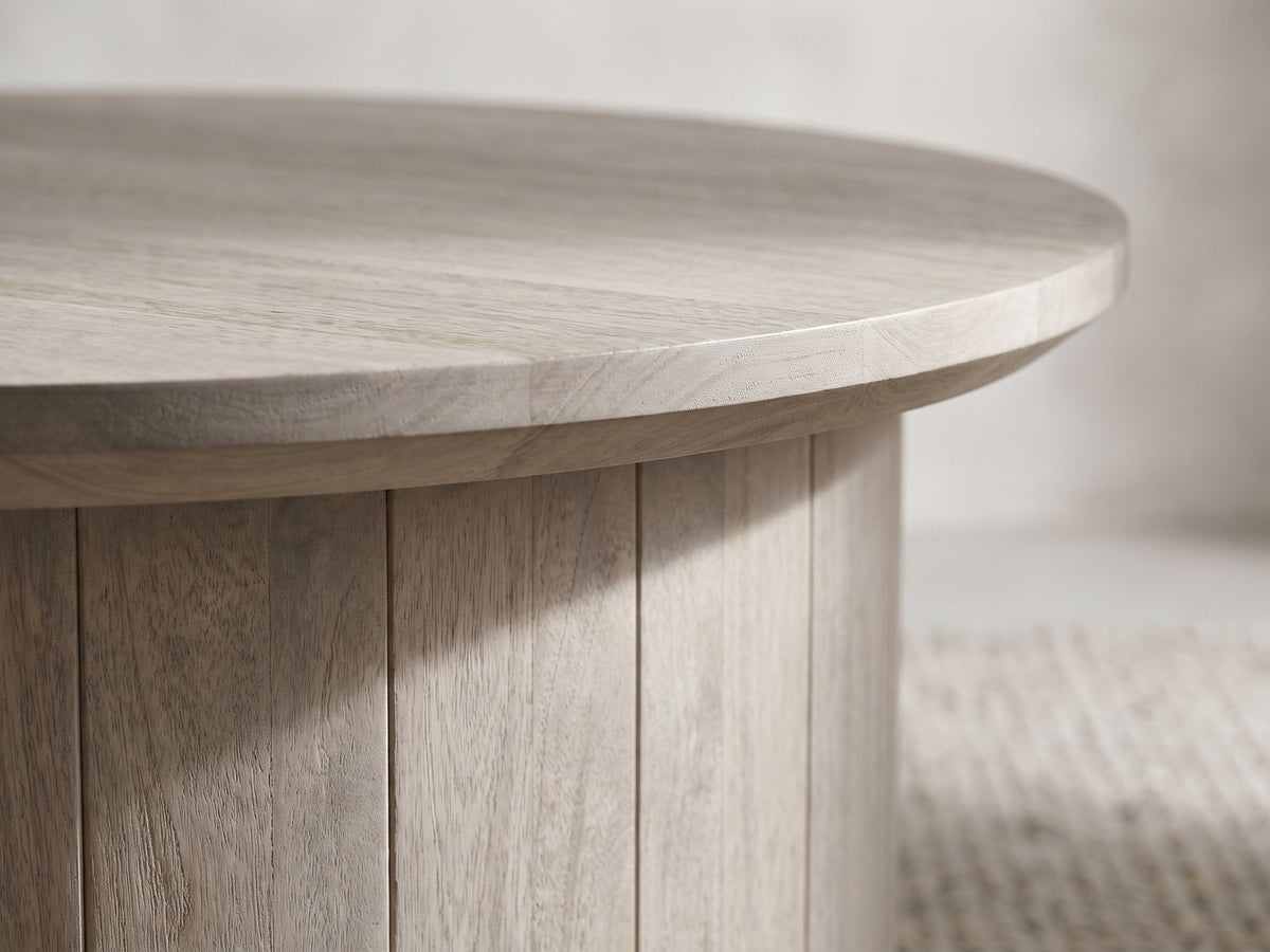 Close-up of the Tolentino Whitewashed Mango Drum Coffee Table: the overhanging top over the vertical mango planks of the drum
