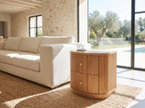 Tolfa Fluted Beech Half-Moon Side Table beside a linen sofa in a poolside villa