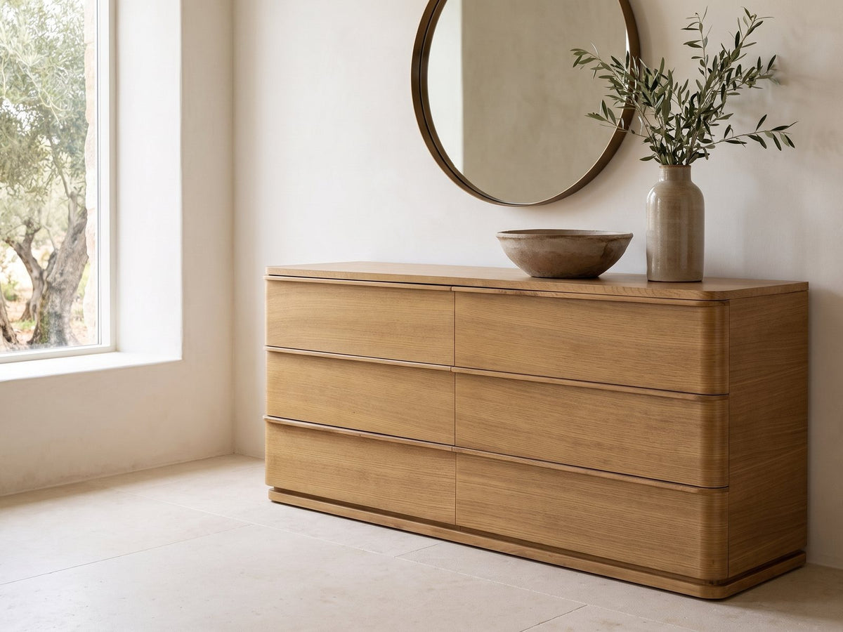 Tolmezzo 72-Inch Natural Oak 6-Drawer Dresser under a round bronze mirror in a villa bedroom