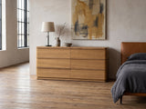 Tolmezzo 72-Inch Natural Oak 6-Drawer Dresser against a plaster wall in an industrial loft bedroom