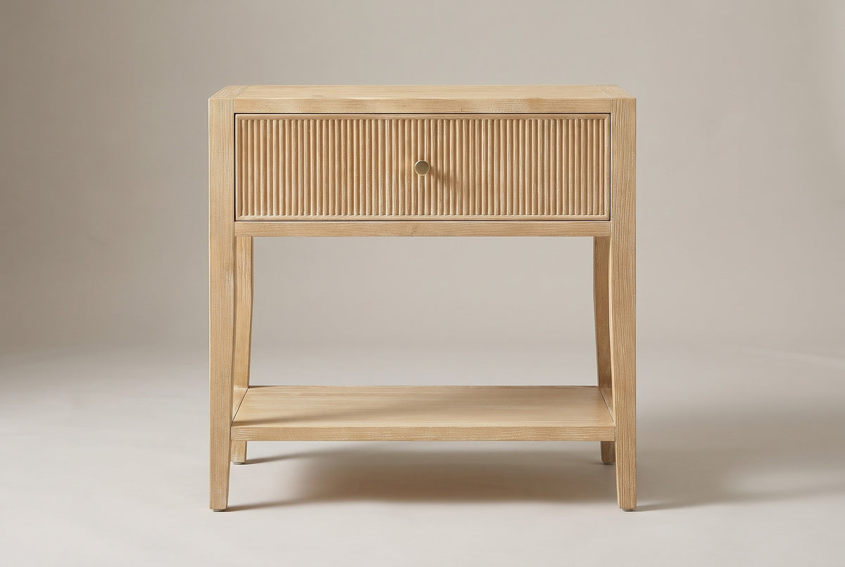 The Tonara nightstand in light natural wood, front view on a light studio backdrop