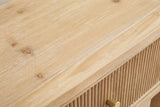 Close-up of the wire-brushed natural wood on the Tonara nightstand: pale grain, small knots and the first reeds of the drawer front