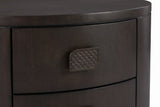 The upper drawer of the Tortoli nightstand: a leaf-shaped bronze-finish pull with a scale texture on espresso eucalyptus veneer
