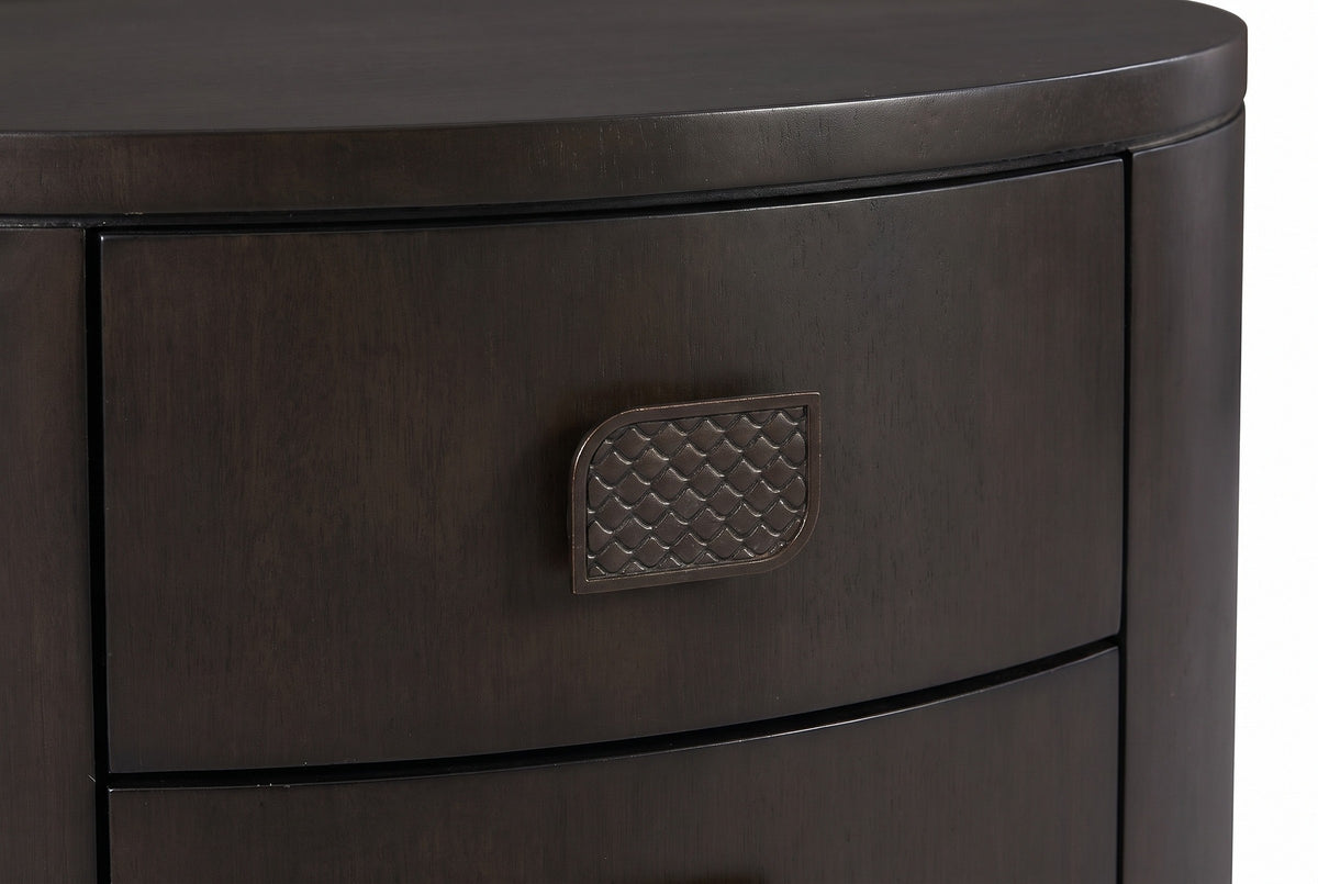 The upper drawer of the Tortoli nightstand: a leaf-shaped bronze-finish pull with a scale texture on espresso eucalyptus veneer