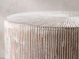 Close-up of the Tortora Carved Whitewash Drum Side Table: the carved top edge over the fine vertical grooves