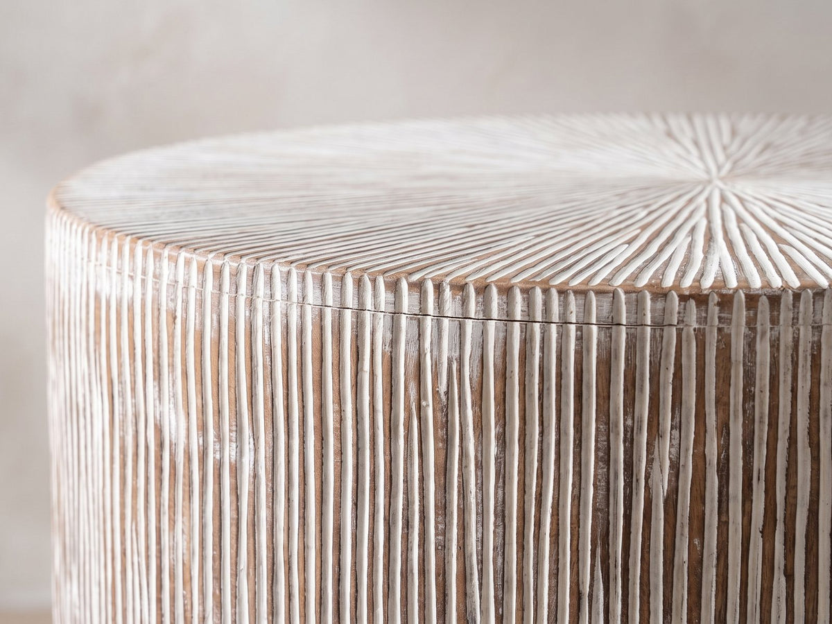 Close-up of the Tortora Carved Whitewash Drum Side Table: the carved top edge over the fine vertical grooves