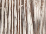Close-up of the Tortora Carved Whitewash Drum Side Table: the hand-carved grooves of the whitewashed side