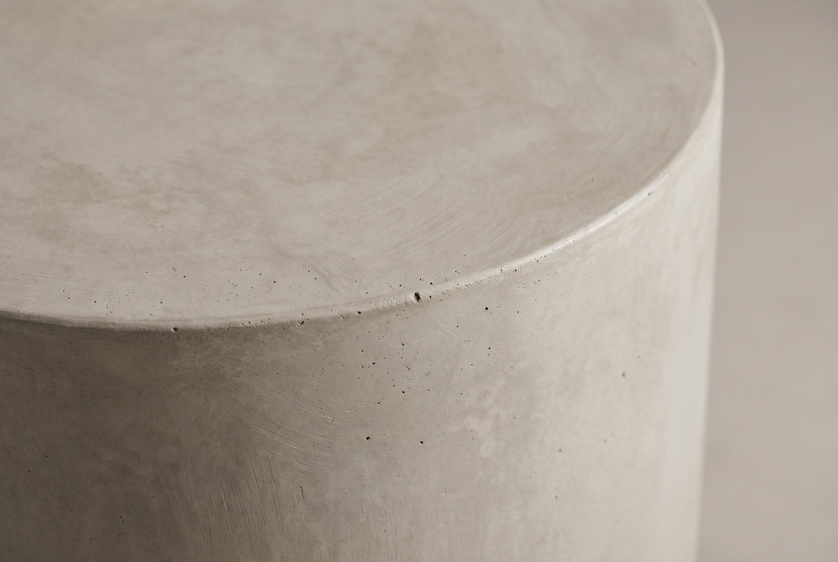 Close-up of the light grey MGO lightweight concrete at the eased top edge of the Trabia side table, showing soft trowel arcs and tiny pinholes