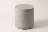 The Trabia light grey concrete smooth drum side table, three-quarter view on a light studio backdrop