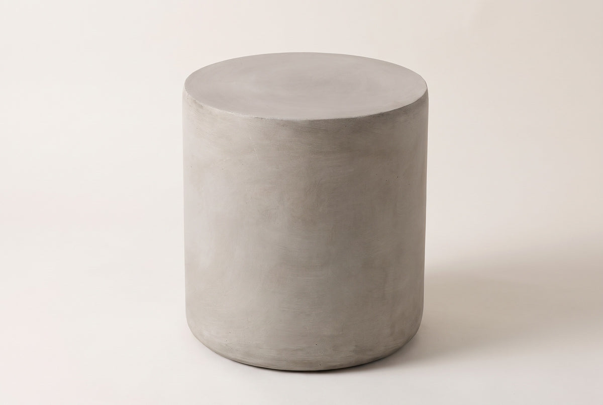 The Trabia light grey concrete smooth drum side table, three-quarter view on a light studio backdrop