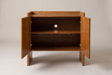 The Trani cabinet with both doors open, showing the oak interior with one shelf and the two hinges on each door