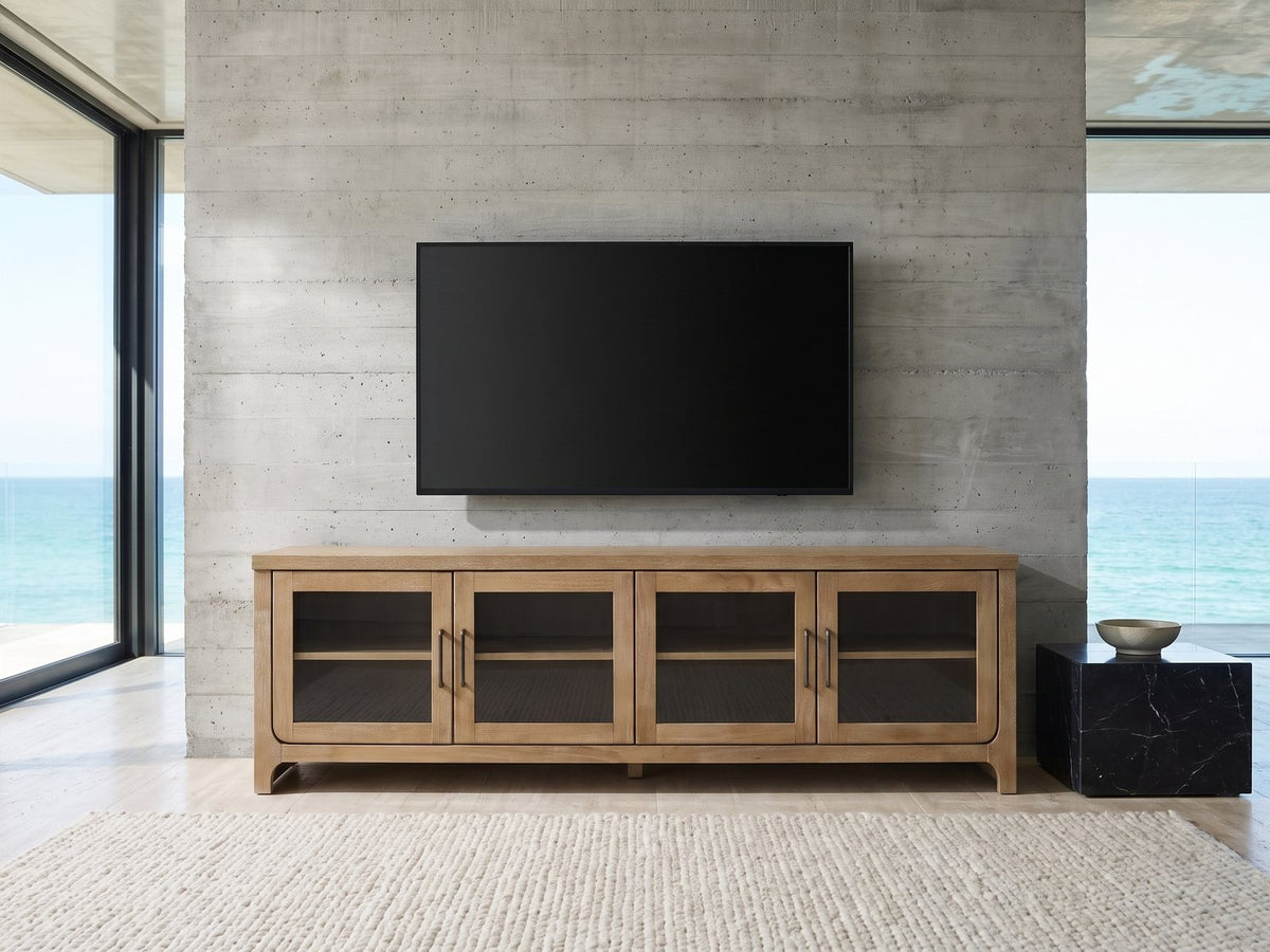 Tremezzo Washed Oak Media Console under a wall-mounted screen in an oceanfront glass house
