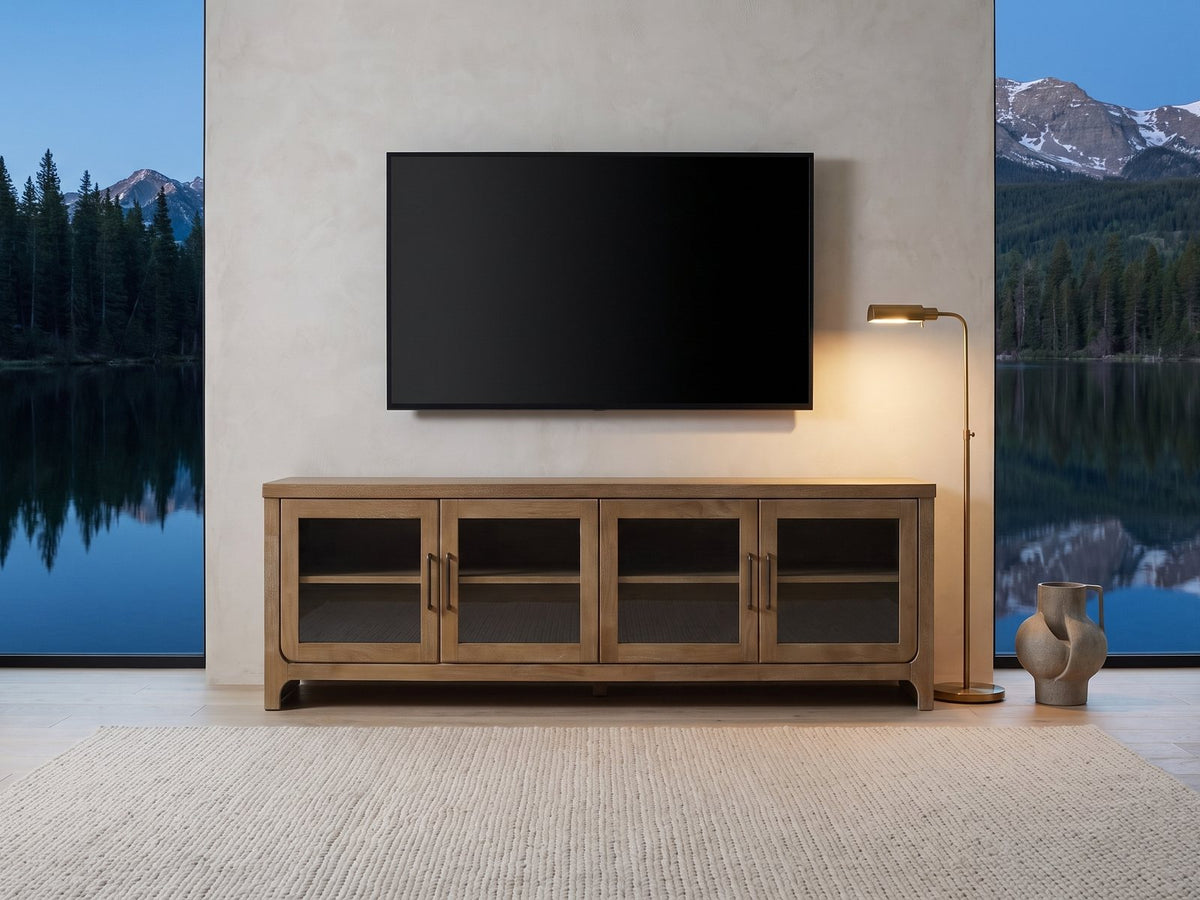 Tremezzo Washed Oak Media Console under a wall-mounted screen in a mountain lake house at dusk