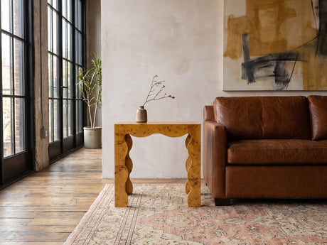 Tricarico Burl Veneer Scalloped Side Table beside a leather sofa in an industrial loft