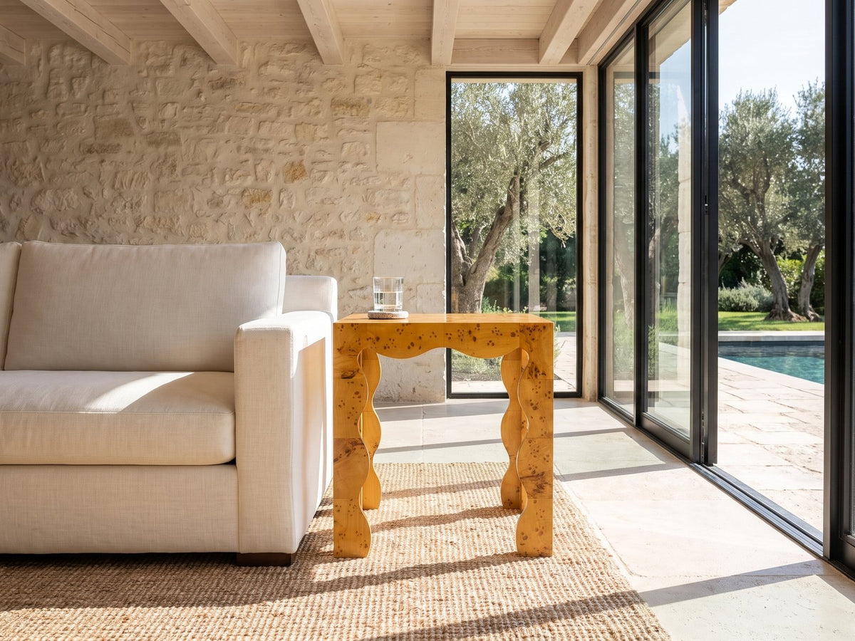 Tricarico Burl Veneer Scalloped Side Table beside a linen sofa in a poolside villa