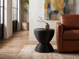 Tricase Black Rattan Hourglass Side Table beside a leather sofa in an industrial loft