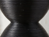 Close-up of the Tricase Black Rattan Hourglass Side Table: the coiled rattan poles at the hourglass waist