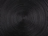 Close-up of the Tricase Black Rattan Hourglass Side Table: the spiral of rattan poles on the top
