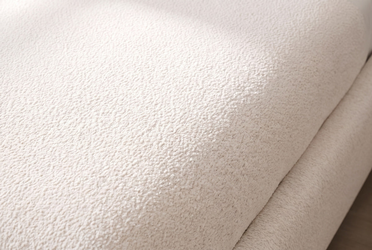 Close-up of the cream white chenille on the Trivento bed, curving over the rounded edge of the base
