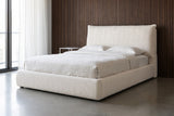 Trivento cream white chenille bed against dark walnut slat panelling in a Chicago loft bedroom with a polished concrete floor and a tall window