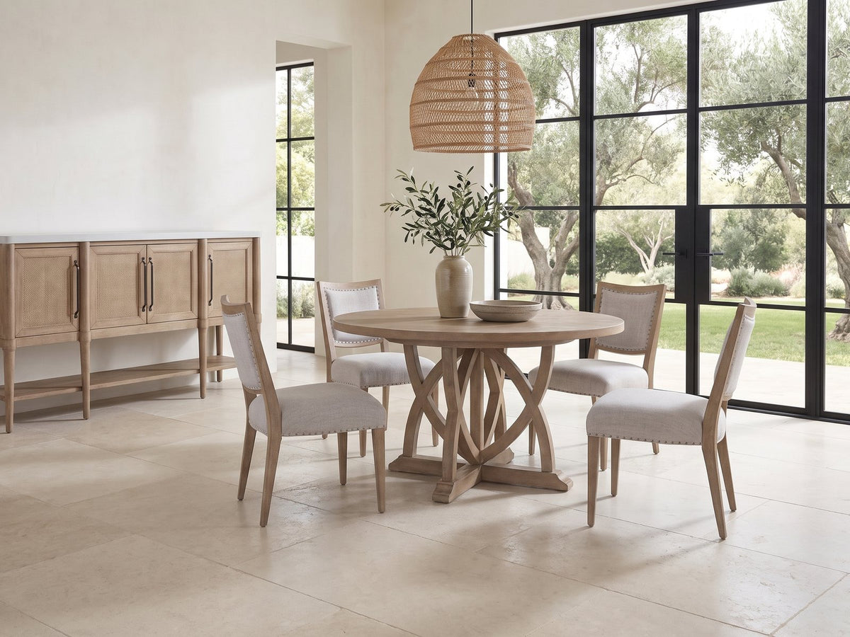 Tropea 54-Inch Round Extending Mindi Veneer Dining Set with 4 Chairs and Server in a sunlit villa dining area with olive trees outside