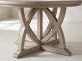 Close-up of the Tropea 54-Inch Round Extending Mindi Veneer Dining Set with 4 Chairs and Server: the crossing curved arches and cross-shaped foot of the table base
