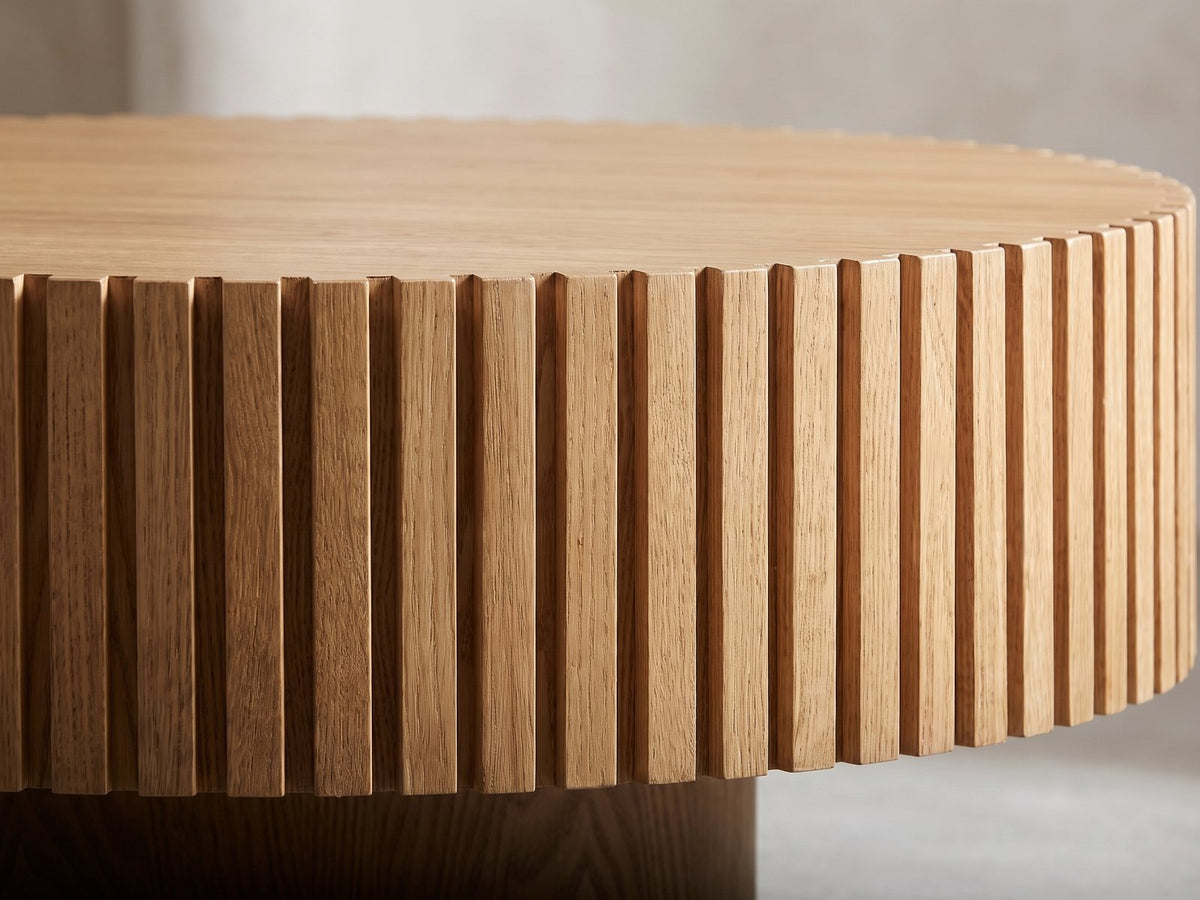 Close-up of the Udine Natural Wood Veneer Fluted Pedestal Coffee Table: the ring of fluted slats under the notched rim of the top