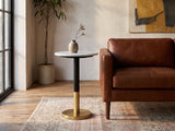 Ugento White Marble Pedestal Side Table beside a leather sofa in an industrial loft
