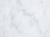 Close-up of the Ugento White Marble Pedestal Side Table: the genuine white marble of the top