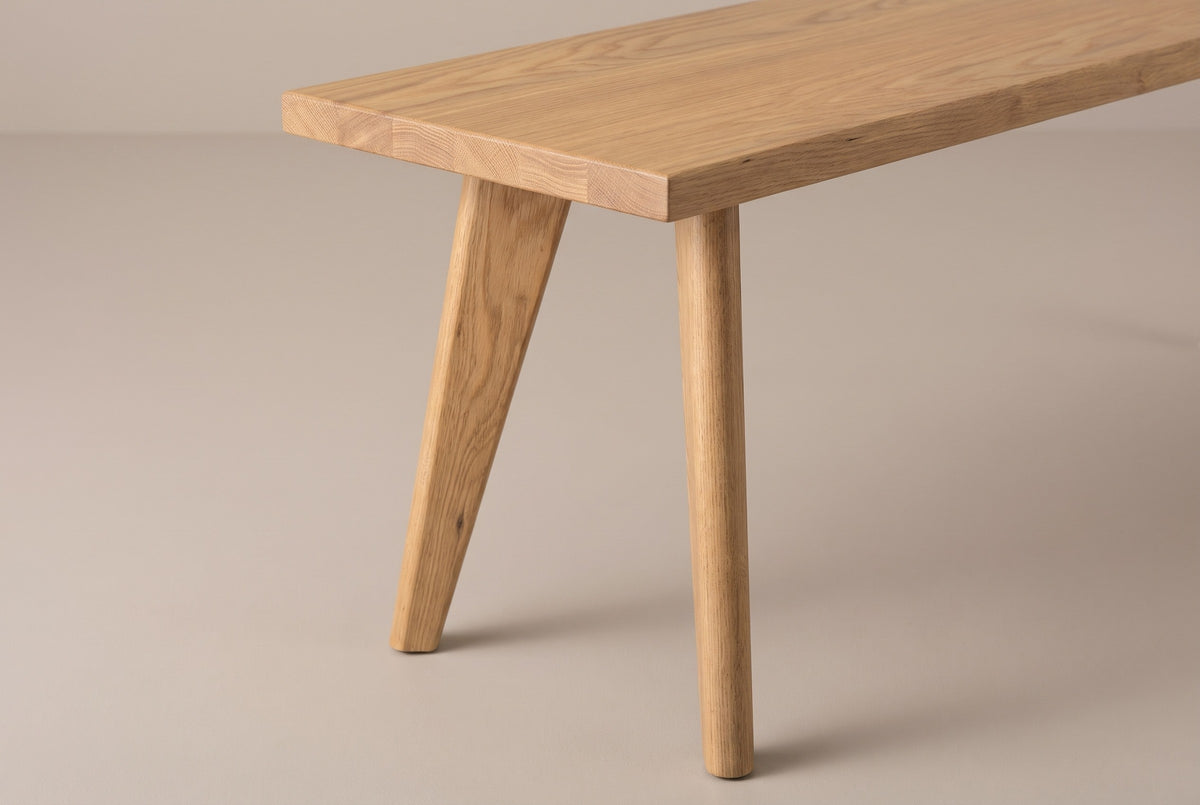 One end of the Umbertide bench: the square corner of the 1 inch oak top with eased edges and glued boards, and the splayed round legs below