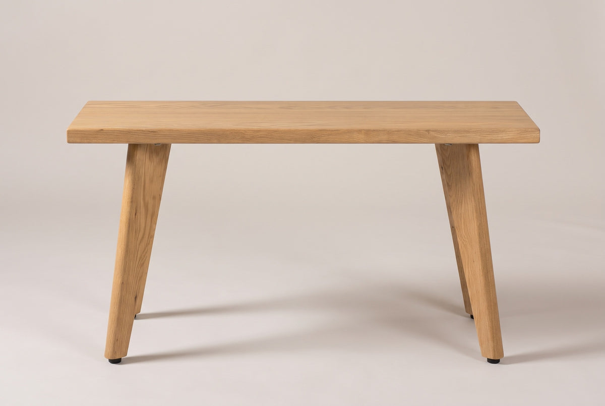 The Umbertide bench in natural red oak, side view on a light studio backdrop