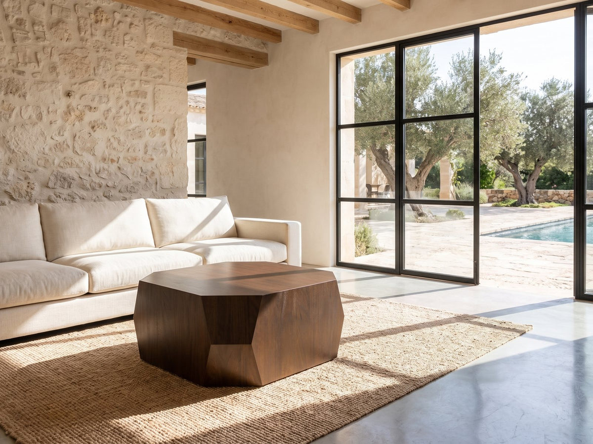 Urbino Acacia Veneer Faceted Coffee Table on a jute rug in front of a linen sofa in a poolside villa