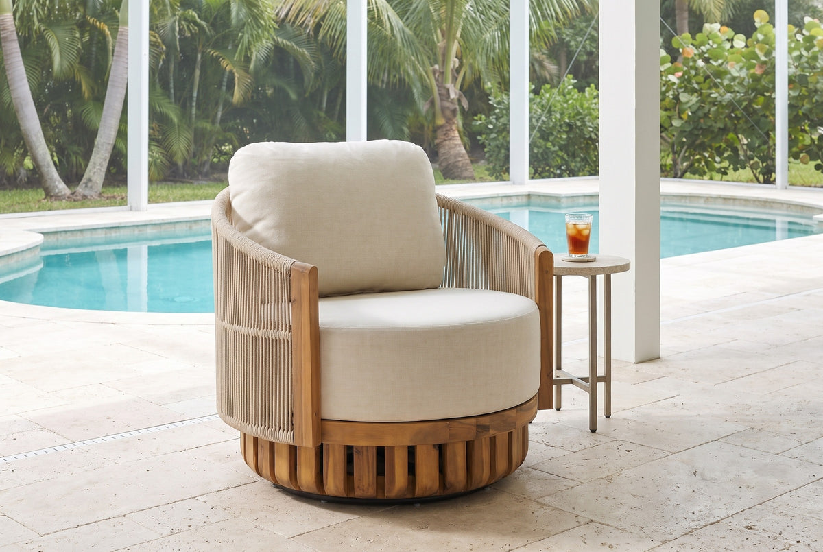 Ustica swivel lounge chair on a covered pool lanai in Naples, Florida, cream travertine pavers, a turquoise pool and palms behind (side table not included)
