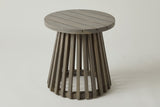 The Valderice round acacia side table in weathered grey, three-quarter view on a light studio backdrop
