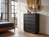 Valdobbiadene 40-Inch Burnished Black 5-Drawer Chest against a plaster wall in an industrial loft bedroom