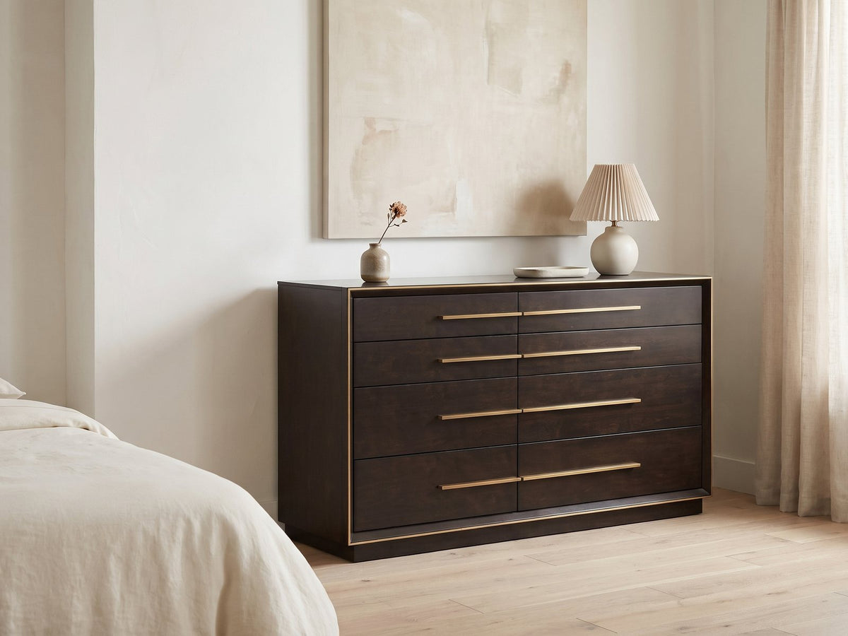 Valeggio 70-Inch Smoked Peppercorn 8-Drawer Dresser against a plaster wall under an abstract canvas in a bright bedroom