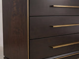 Close-up of the Valeggio 70-Inch Smoked Peppercorn 8-Drawer Dresser: the long antique-brass bar pulls and the thin brass band at the front corner