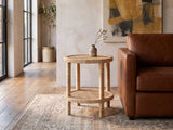 Valsinni Rattan Round Two-Tier Side Table beside a leather sofa in an industrial loft