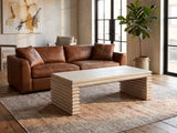 Varallo Reclaimed Pine Waterfall Coffee Table on a vintage rug in front of a leather sofa in an industrial loft
