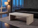 Varallo Reclaimed Pine Waterfall Coffee Table on a wool rug in front of a velvet sofa in a city penthouse at blue hour