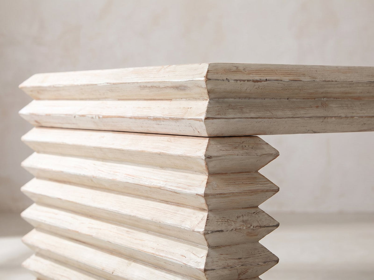 Close-up of the Varallo Reclaimed Pine Waterfall Coffee Table: the stacked, chevron-edged pine boards of one leg under the top