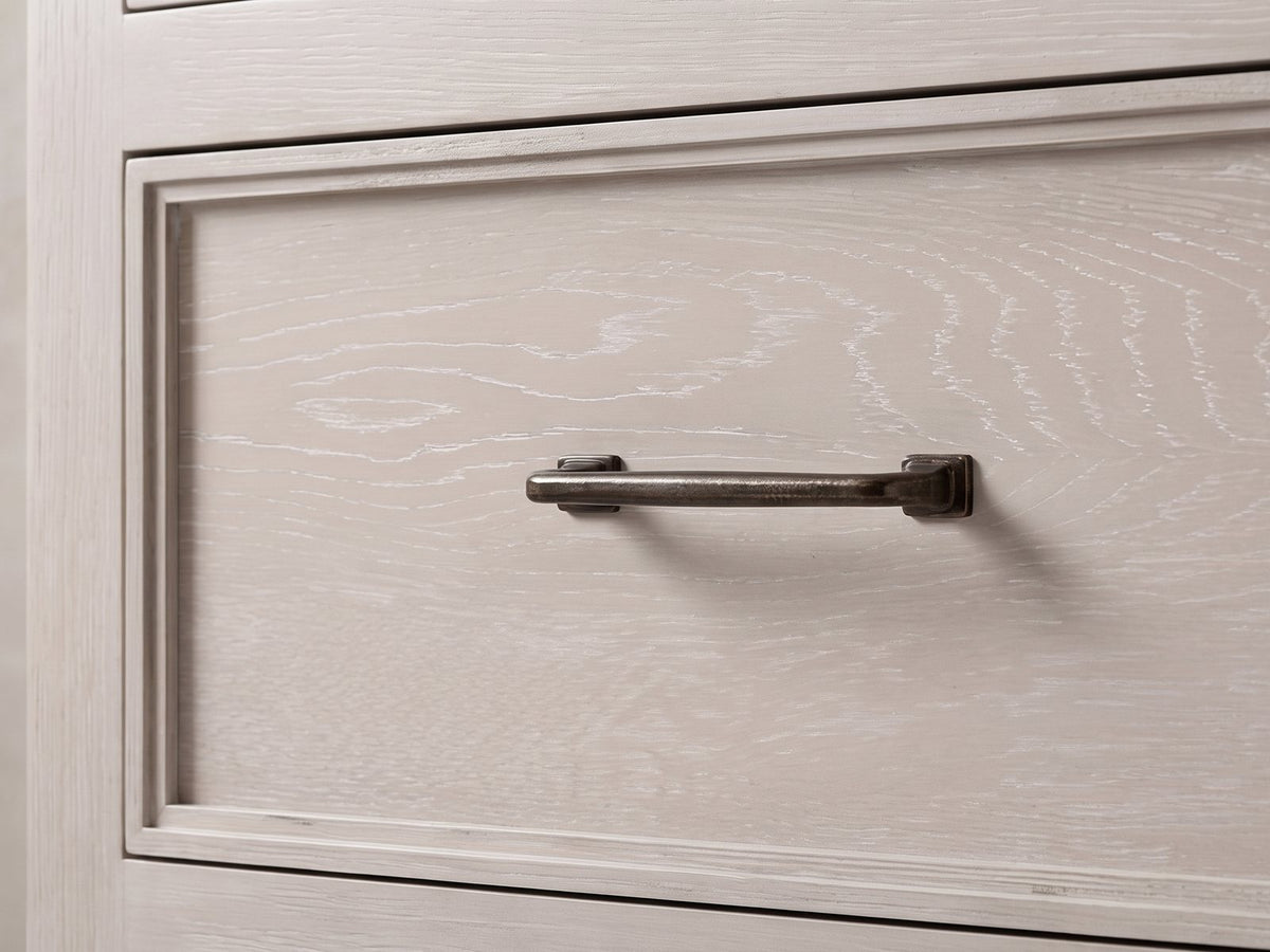 Close-up of the Venzone 64-Inch Cerused Oak 6-Drawer Dresser: the dark bronze bar pull on a moulded cerused oak drawer front