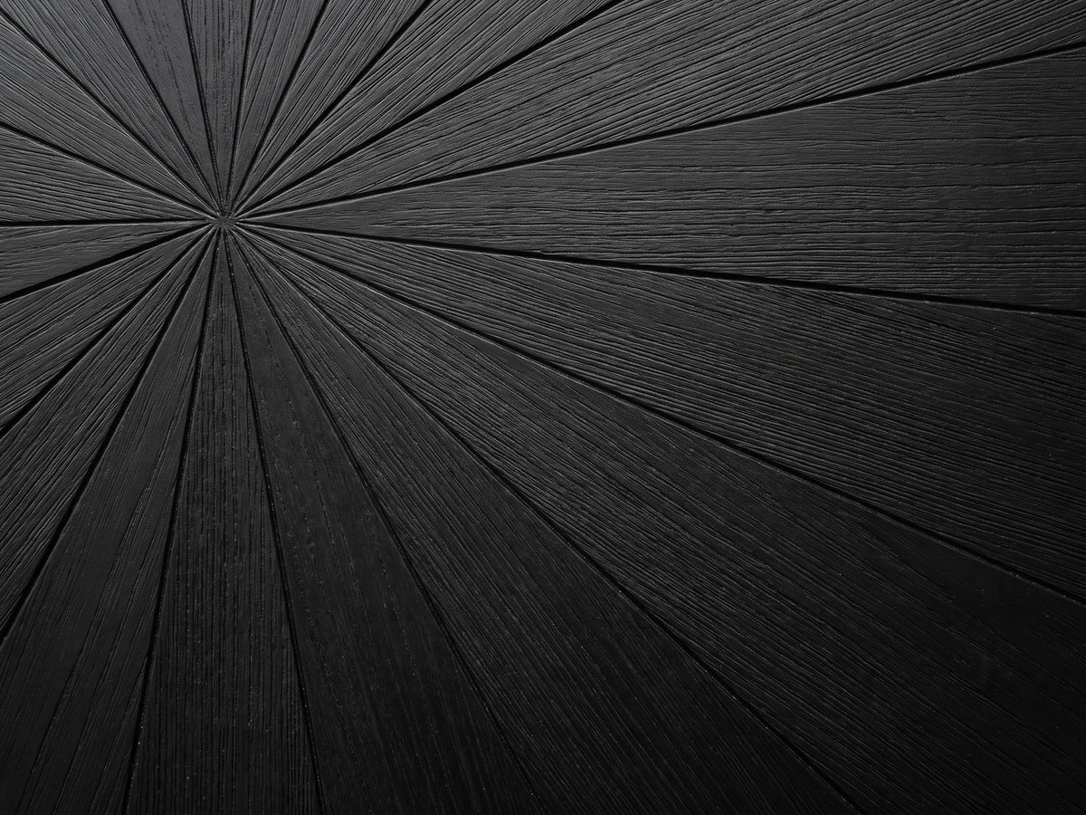 Close-up of the Verzino 47-Inch Round Black Acacia Sunburst Dining Table: the black wire-brushed acacia sunburst top