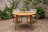 Vittoria round acacia dining table in a Savannah courtyard with an old grey brick wall, creeping fig and herringbone brick paving (chairs and tableware not included)