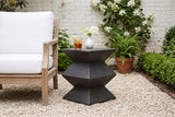 Zafferana geometric side table on pale gravel in an Atlanta walled garden with a whitewashed brick wall and hydrangea, beside a teak armchair (chair, glass and vase not included)