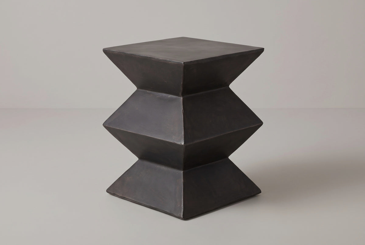 The Zafferana charcoal bronze geometric concrete side table, corner view on a light studio backdrop