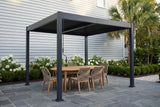 Zingaro black louvered pergola over a bluestone patio beside a grey-blue clapboard house in Beaufort, South Carolina, with white hydrangeas and a palmetto (furniture not included)