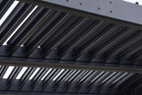 Close-up of the louver blades of the Zingaro pergola in matte black, seated on pivot caps along the beams
